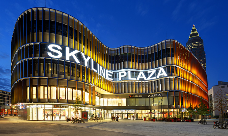 Ein modernes Einkaufszentrum mit dem Schriftzug Skyline Plaze am späten Abend