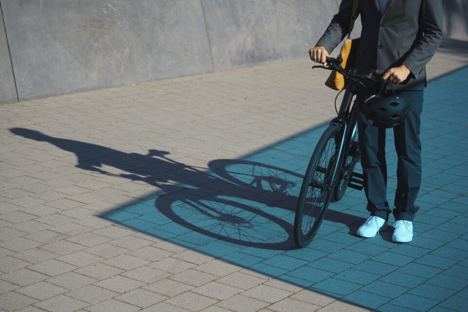 Ein Mann im Anzug schiebt ein Fahrrad